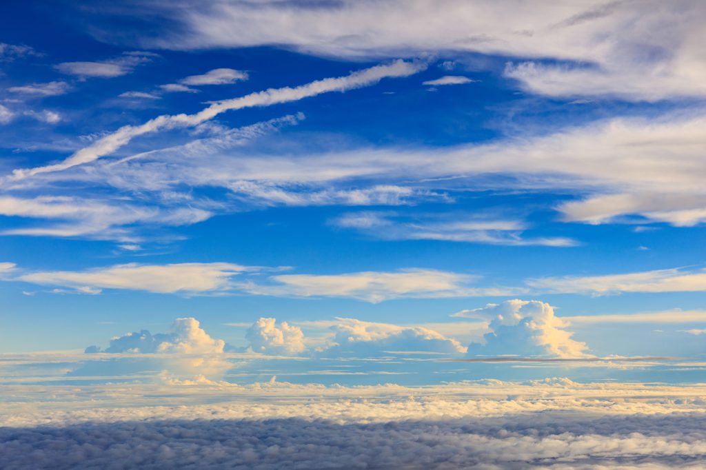 Sun shining on distant cloud formations, contrasted with closer cloud shadow